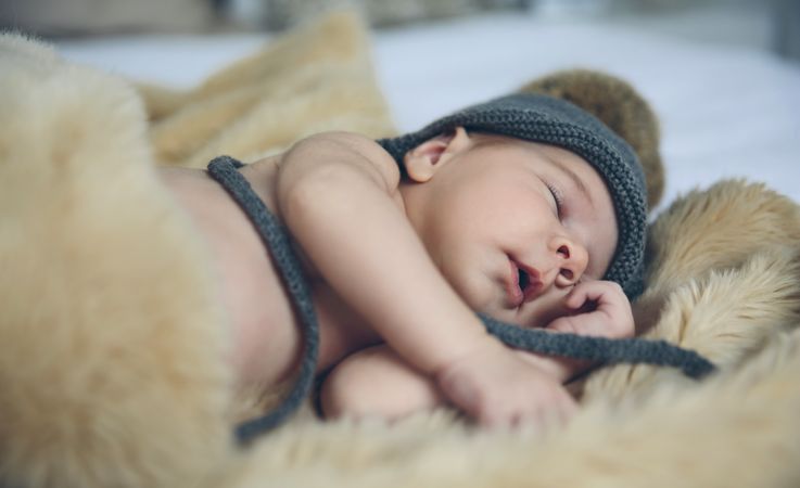 Baby girl with pompom hat sleeping