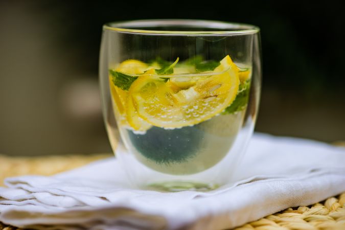 Side view of gin and tonic cocktail with lemon and mint
