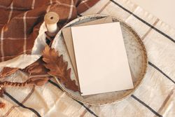 Blank card on ceramic plate on autumn themed table setting