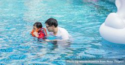 Father helping son swim in lifejacket 4dD3a4