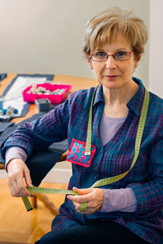 dressmaker posing with sewing materials
