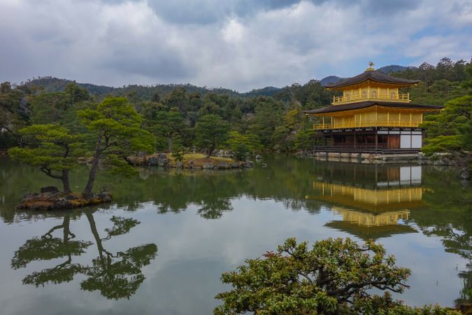 Kinkaku-ji Buddhist temple  near green trees and lake