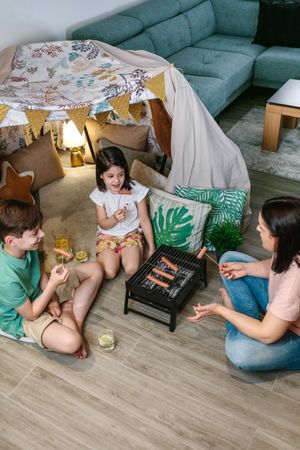 Top view of family grilling and eating sausages on barbecue