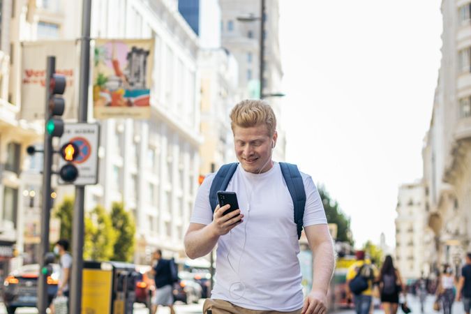 Latino man with albinism using smartphone in the city