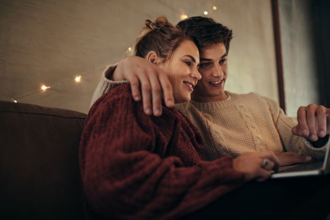 Couple with laptop in cozy living room