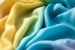 Close up Gradient yellow blue pink and green fabric wavy crumpled background texture.