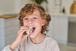 Funny boy eating rolls at home