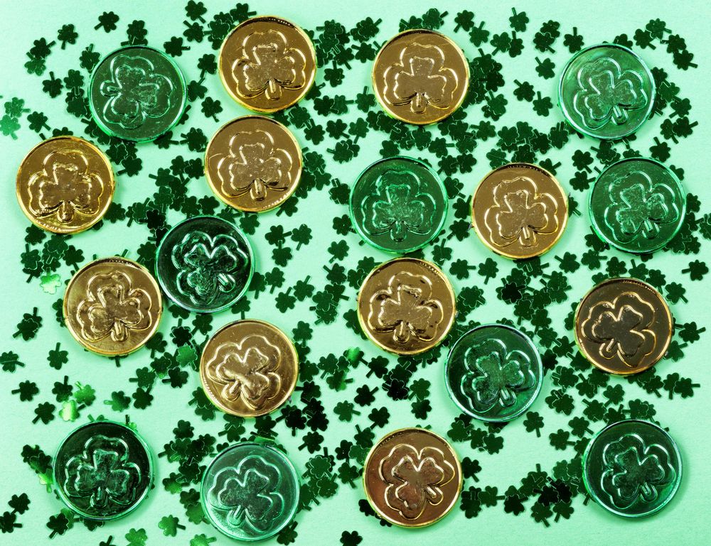 St Patrick’s Day with shamrocks and shiny coins on green background
