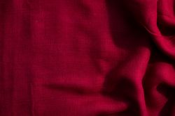 Red fabric wavy crumpled background texture with copy space.