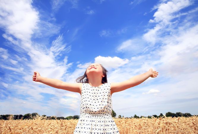 Joyful young girl with Down syndrome in a field
