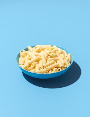 Penne pasta bowl minimalist on a blue background