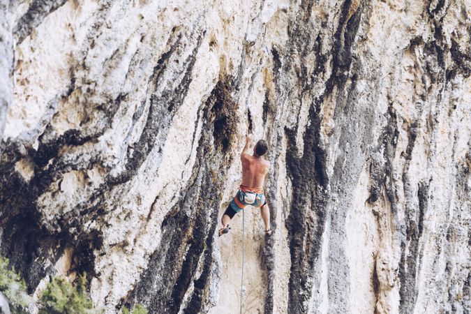Anonymous man climbing rock