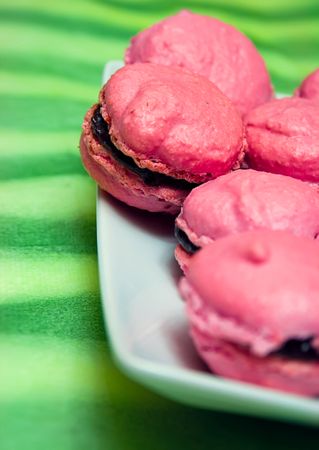 Pink macarons on green background.