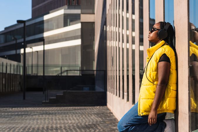 Woman listening to music while leaning on a wall