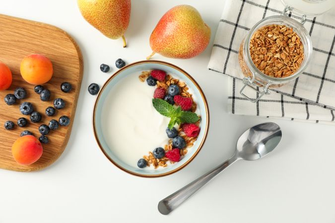 Composition with yogurt dessert and ingredients on blank background, top view