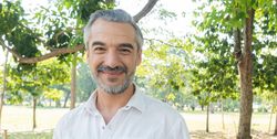 Mature grey haired man standing outside in tree filled park