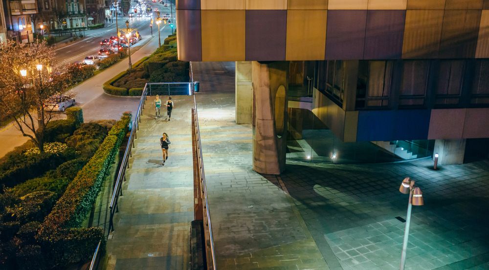 Women friends runners training on the city at night seen from above bridge