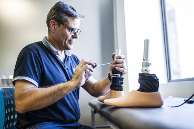 man fixing a prosthesis in a workshop