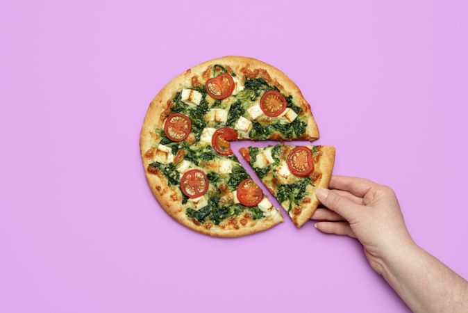 Woman hand taking a slice of pizza