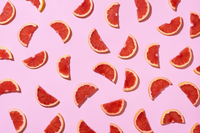 Ripe grapefruit slices pattern on pink background