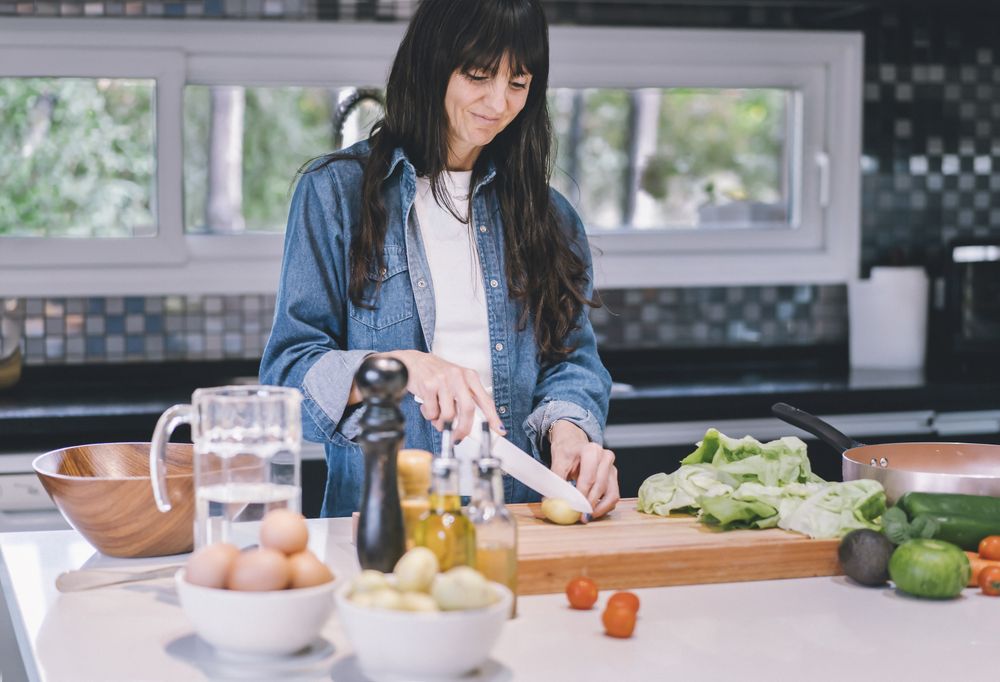 Smiling woman preparing delicious food at home