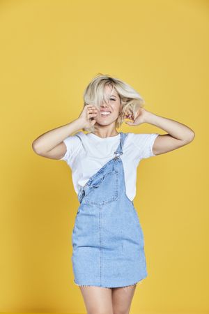 Trendy blonde female in denim sundress