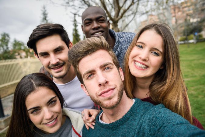 Group of friends looking at camera and posing for selfie