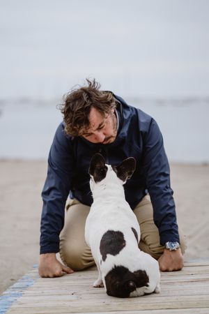 Man and dog resting on beach together