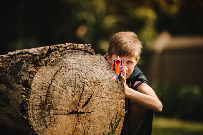 Boy playing with toy gun outdoors