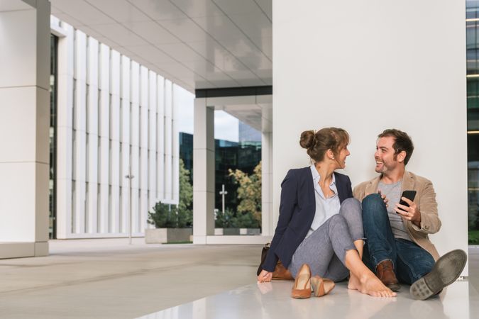 Businesspeople hugging and using smartphone on street