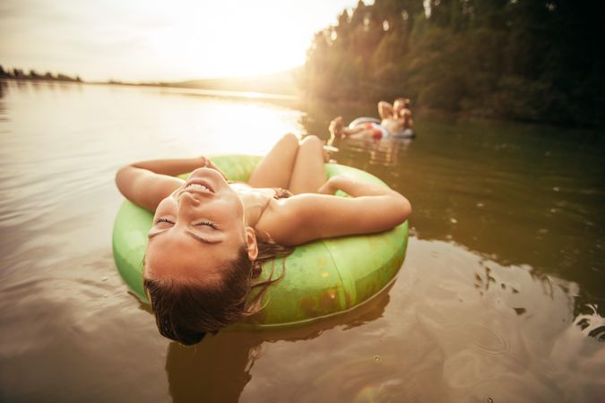 Closeup portrait of young woman with her eyes closed relaxing on inflatable ring