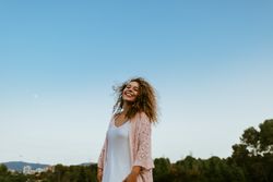 Happy woman raising arms to sky