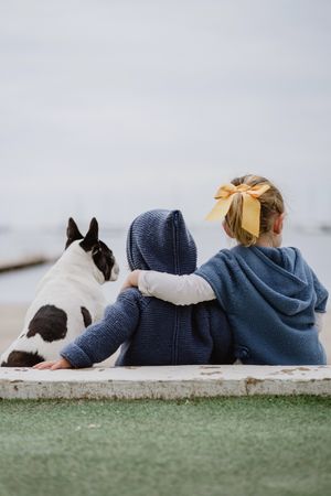 Kids hugging dog on beach