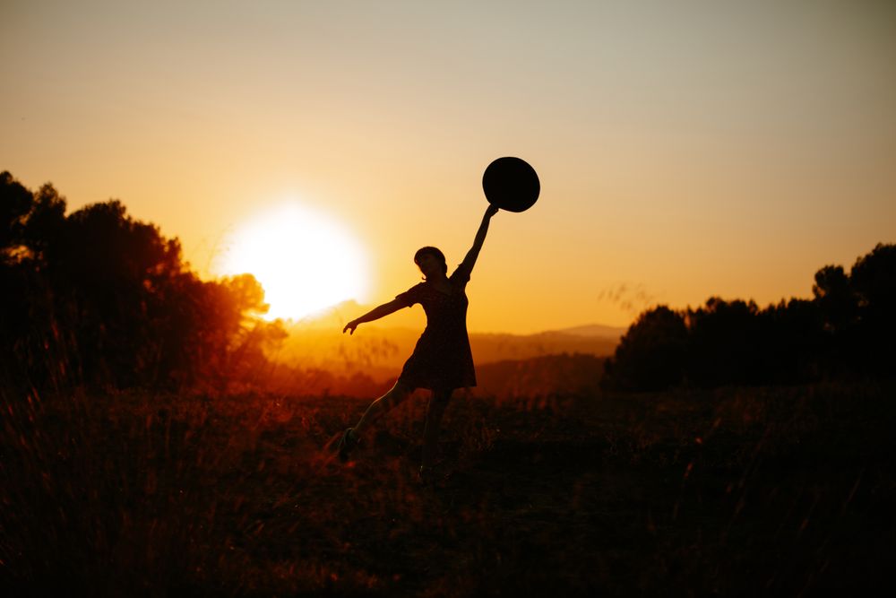 Anonymous woman dancing during sundown