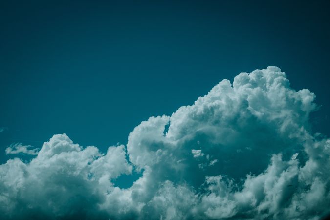 Fluffy clouds against dark blue sky