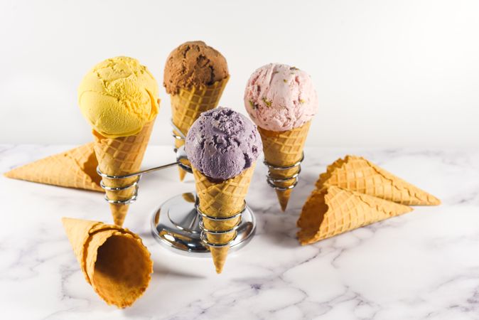 Ice cream cone stand with waffle cones and four different scoops