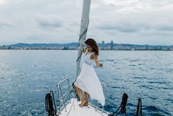 Barefoot bride resting on yacht bow