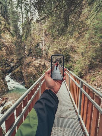 Tourist taking photo while walking on footpath
