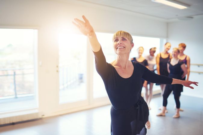 Mature woman doing ballet pose in class