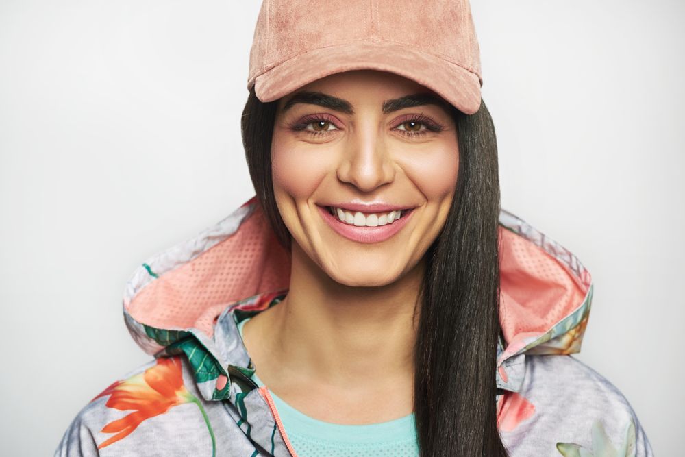 Portrait of confident smiling woman pictured in colorful printed floral hoodie