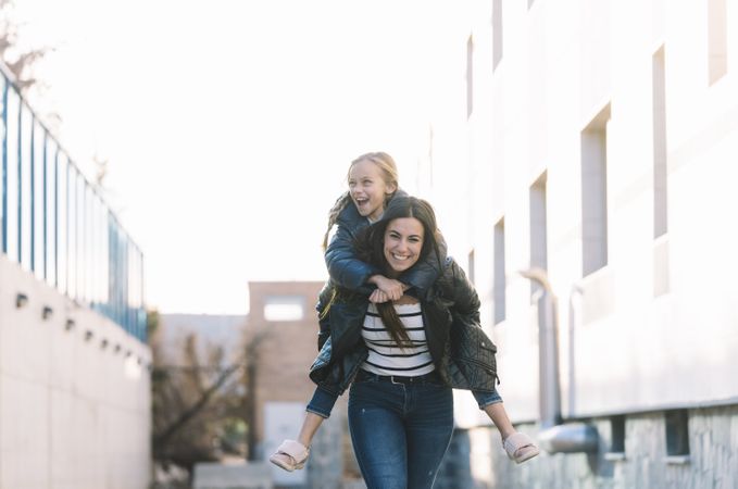 Woman doing young sister piggyback