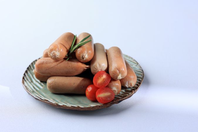 Close Up Fresh Raw Sausages and Rosemary Isolated on White