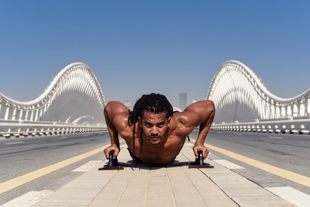 Man doing push up on bridge during daytime