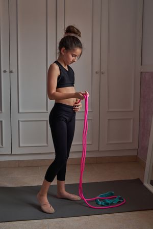 Focused sportive girl preparing to jump rope