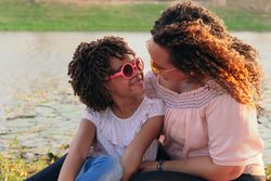 Joyful mother and daughter laughing outdoors on summer vacation