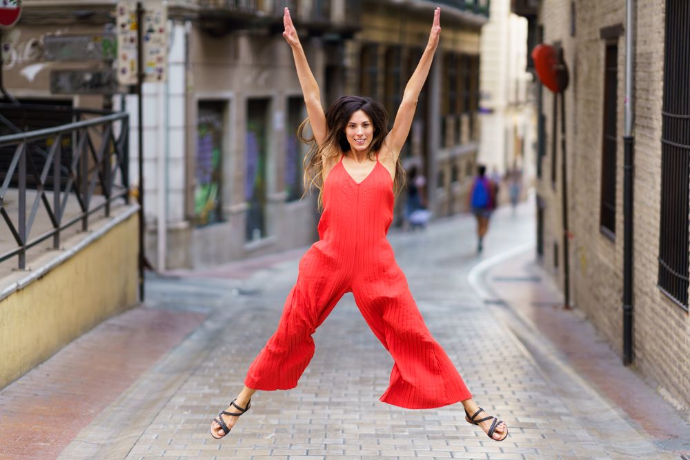 A Joyful Jump in a Vibrant Red Outfit on a Bustling City Street Full of Energy Today