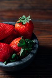 Fresh ripe strawberries in concrete bowl