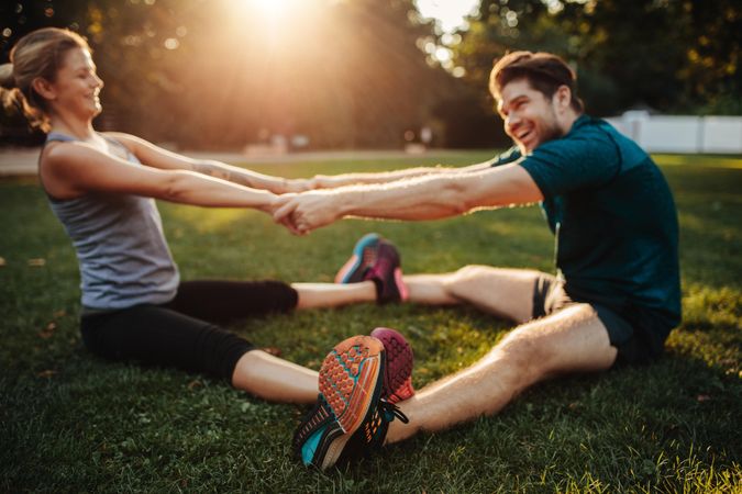 Man and woman sitting together holding hands and exercising