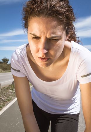 Close up of woman's face as she working out on road