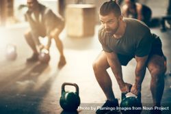 Man exercising with kettlebell in gym 4B2oX4